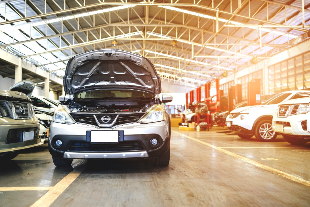Car with open hood in a warehouse setting